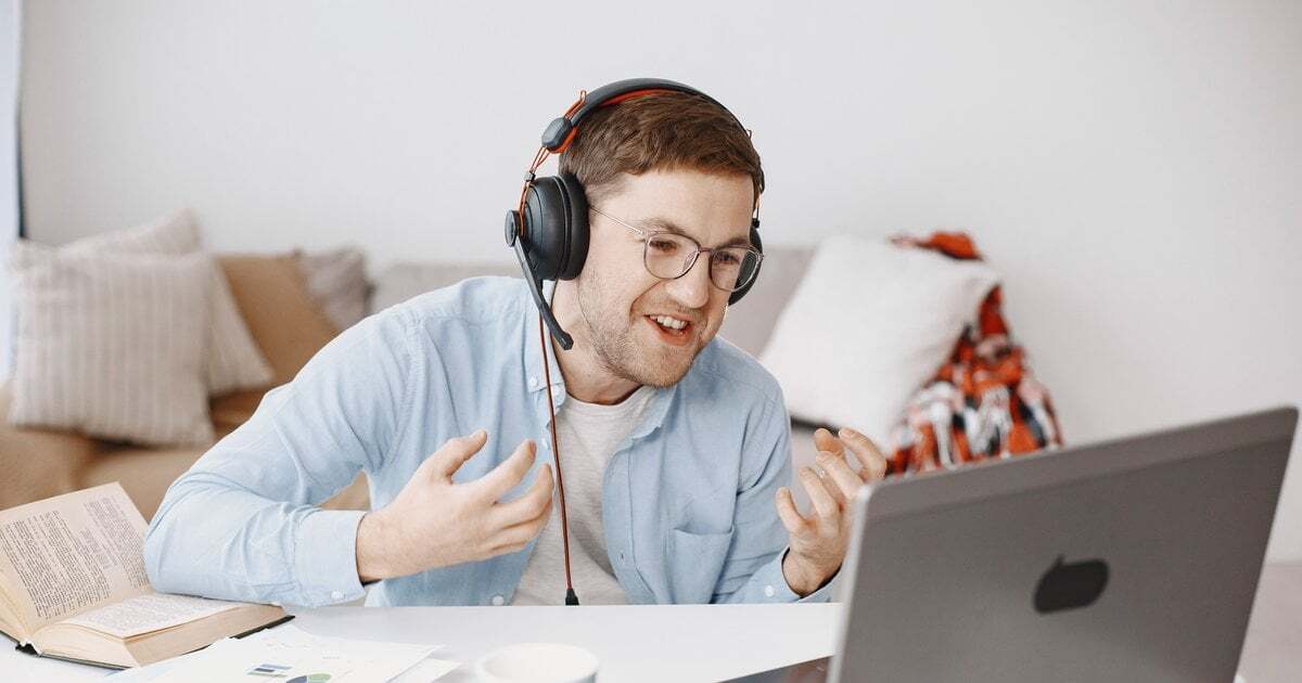A tutor wearing a headset teaching online from a home office